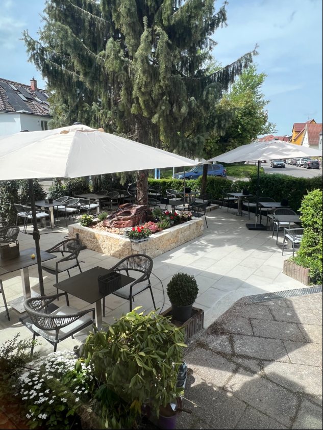 Terrasse mit Sonnenschirmen und großem Baum